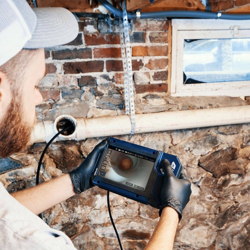 Technik zavádí kameru do šachty